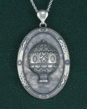 Pendentif ovale, motif de montgolfière ancienne esprit royauté Louis XIV, et cadre à motifs de météo en argent made in France. Vue de face | Res Mirum