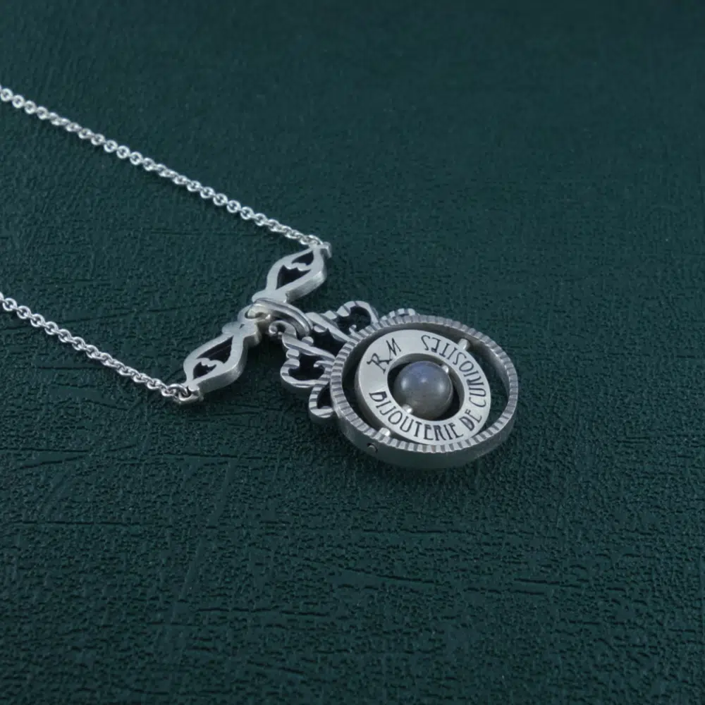 Collier sphère armillaire et arabesques avec axe tournant autour d'une perle de labradorite en argent massif made in France. Vue de côté | Res Mirum