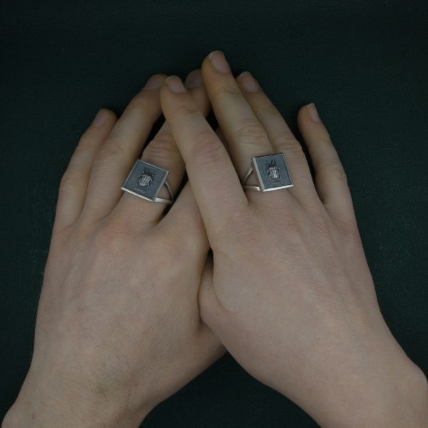 Bague carrée avec scarabée-punaise arlequin dans petit cadre entomologique en argent 925 fait main portée sur mains | Res Mirum