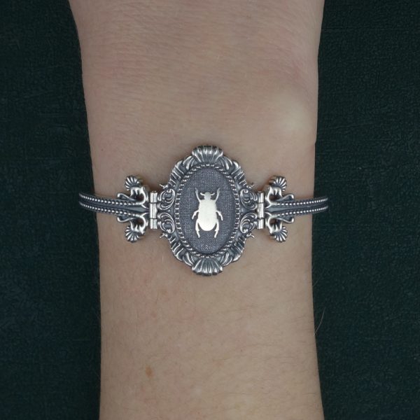 Bracelet jonc semi rigide à motif de scarabée et moulures baroque inspiré des muséums d'histoire naturelle made in France porté sur poignet | Res Mirum