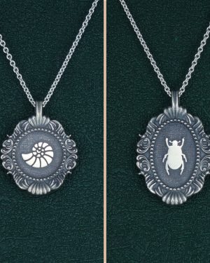 Petit collier nautile coquillage, ou ammonite et scarabée noir égyptien dans cadre baroque rond et ovale inspirés des cabinets de curiosités de fabrication artisanale. Vue de face | Res Mirum