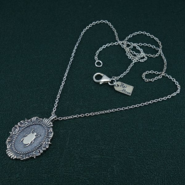 Petit collier scarabée noir égyptien dans cadre ovale baroque inspiré des cabinets de curiosités de fabrication artisanale. Vue complet | Res Mirum