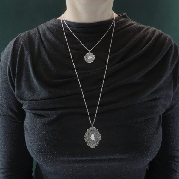 Pendentif ovale scarabée noir égyptien sur chaîne sautoir & collier nautile marin dans cadres baroques inspirés des collections d'insectes des musées en argent. Portés | Res Mirum