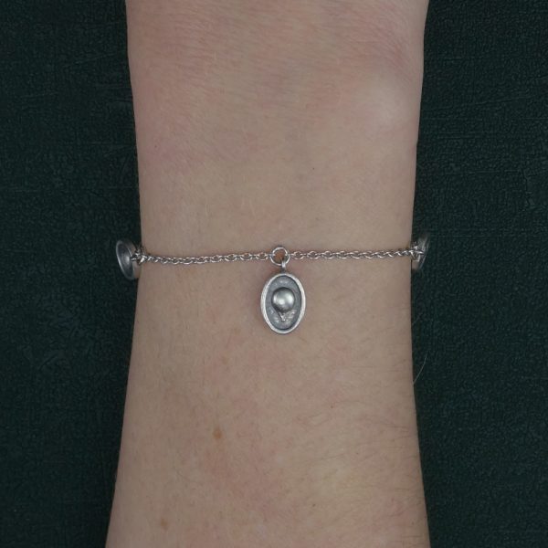 Bracelet à petites breloques façon camées, reproductions de mini montgolfières rétro de fabrication artisanale porté sur poignet | Res Mirum