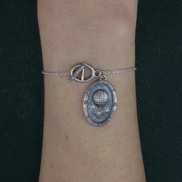 Bracelet toogle avec breloque ovale et motif de ballon ancien d'époque XVIIIe siècle en argent 925 porté sur poignet | Res Mirum