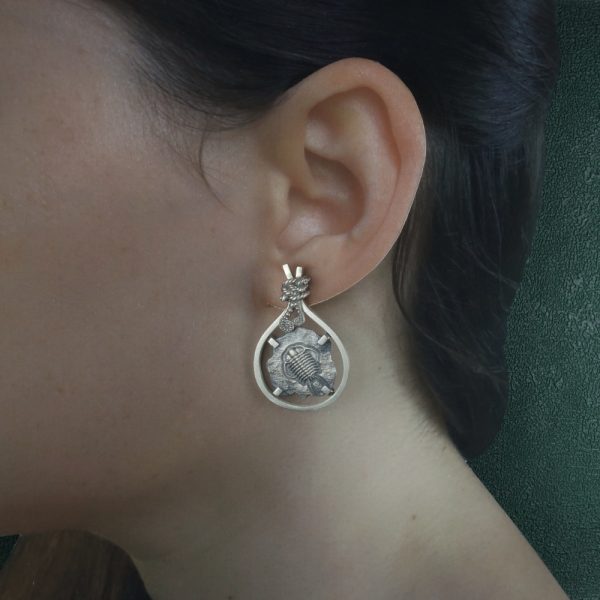 Boucles d'oreilles asymétriques avec motifs de fossiles de Limule & de Trilobite et de décors de fougères en argent fabriquée en France artisanalement portées trilobite | Res Mirum