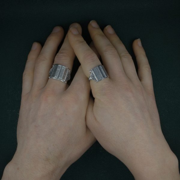 Bague imaginée autour d'un livre ouvert sur son lutrin, dans un esprit médiéval et rétro en argent patiné fabriquée en France portée sur mains | Res Mirum