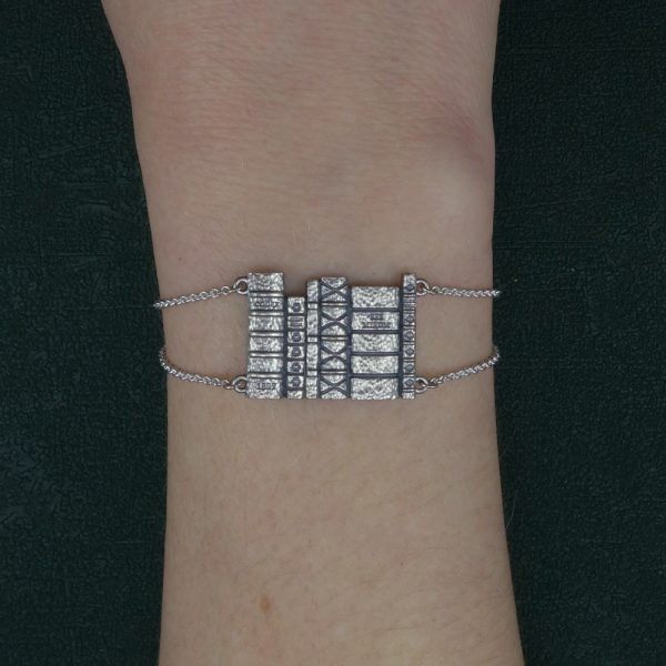 Bracelet inspiré de grimoires rangés dans une bibliothèque sur une chaîne, fabriqué par nos soins en argent massif porté sur poignet | Res Mirum