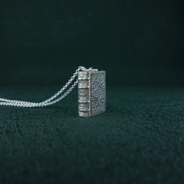 Pendentif créé dans l'esprit d'une mini reproduction d'un livre ancien, ouvragé et décoré façon codex du Moyen-Age de fabrication Française en argent 925 vue côté couverture | Res Mirum