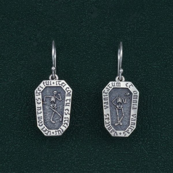 Boucles d'oreilles en forme de cercueil avec un squelette et inscription latines, bijou avec message de memento mori. Vue de face | Res Mirum