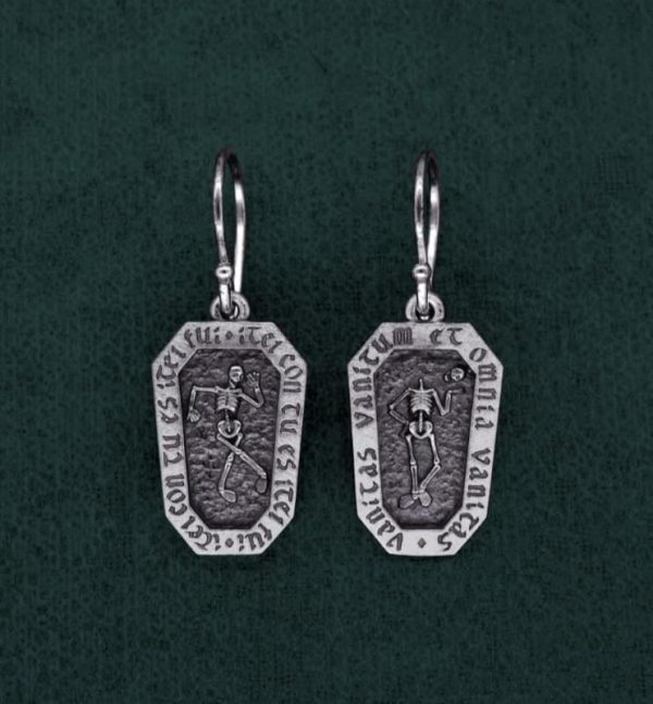 Boucles d'oreilles en forme de cercueil avec un squelette et inscription latines, bijou avec message de memento mori. Vue de face | Res Mirum