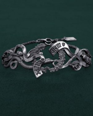 Bracelet comprenant les éléments symboliques d'une vanité de la Renaissance : couronne de lauriers, phylactère gravé Carpe diem, serpent, citron pelé, pinceaux et verre. Vue de face | Res Mirum