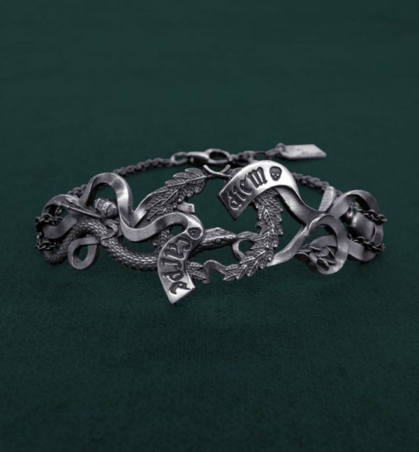 Bracelet comprenant les éléments symboliques d'une vanité de la Renaissance : couronne de lauriers, phylactère gravé Carpe diem, serpent, citron pelé, pinceaux et verre. Vue de face | Res Mirum