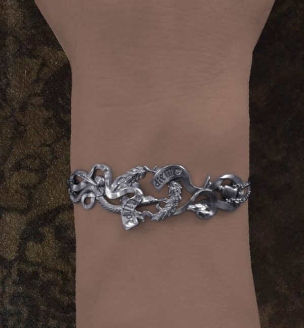 Bracelet comprenant les éléments symboliques d'une vanité de la Renaissance : couronne de lauriers, phylactère gravé Carpe diem, serpent, citron pelé, pinceaux et verre. Vue porté | Res Mirum