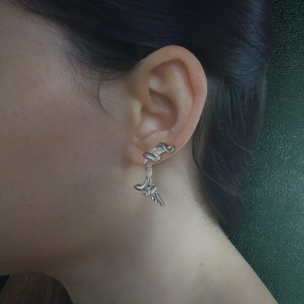 Boucles d'oreilles représentant une nature morte, bijou allégorie de la mort avec les symboles du serpent, la plume d'écriture, la bougie, coquelicot et épi de blé, phylactère. Vue portée petit modèle | Res Mirum